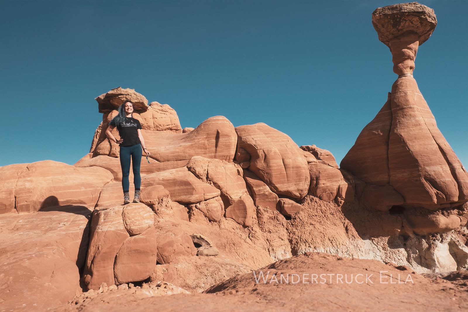 traveling photographer and writer Wanderstruck Ella happily hiking hoodoos in Utah