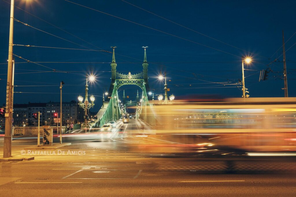 traffic blurs across liberty bridge in budapest