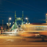 night shot of bridge in Budapest, yellow tram blurred by long exposure