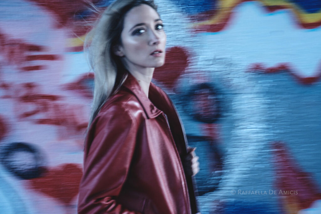 photo of woman in red jacket using a panning technique and slower shutter speed