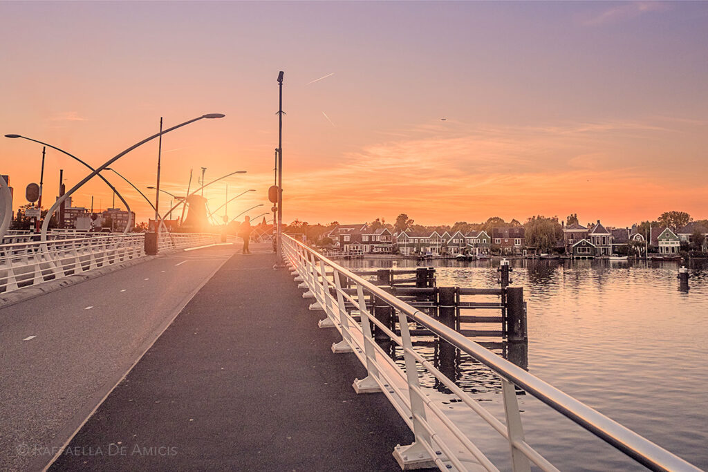 the sun sets on the bridge from Zaanse Schans newer town to older, leading lines and golden color
