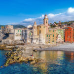 Camogli, Italy viewed from the sea with colorful buildings and blue sky